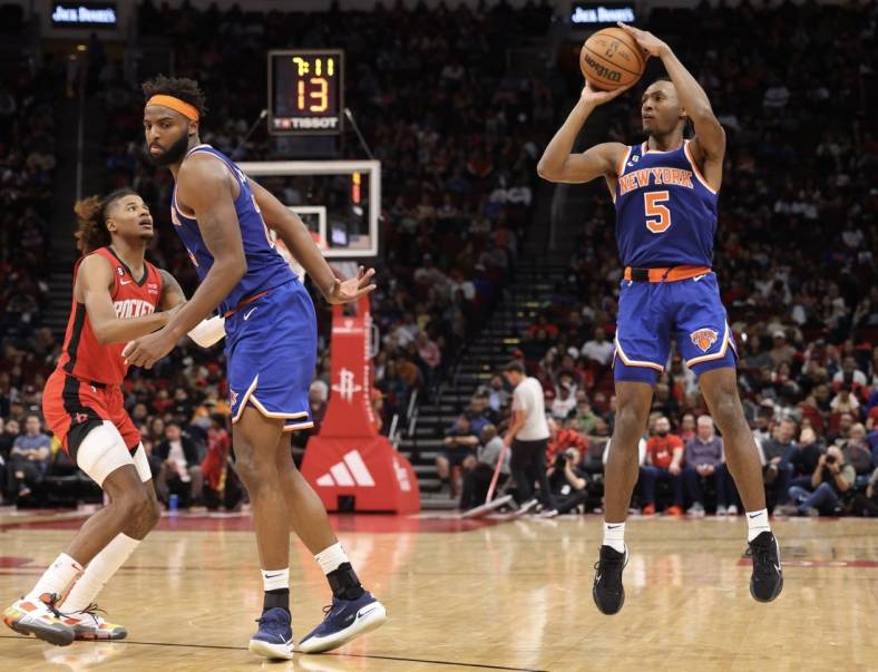 Dec 31, 2022; Houston, Texas, USA; New York Knicks guard Immanuel Quickley (5) shoots as  center Mitchell Robinson (23) sets up a pick against Houston Rockets guard Jalen Green (4) in the third quarter at Toyota Center. Mandatory Credit: Thomas Shea-USA TODAY Sports