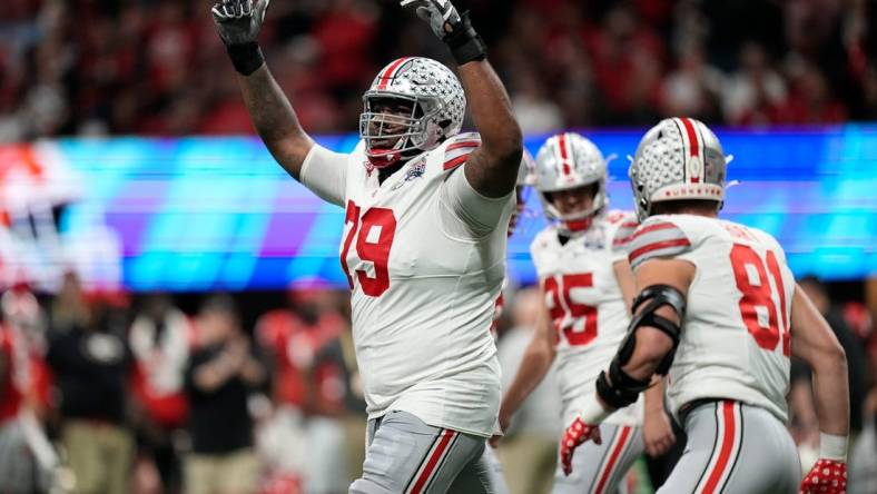 Dec 31, 2022; Atlanta, Georgia, USA; Ohio State Buckeyes offensive lineman Dawand Jones (79) celebrates a touchdown by wide receiver Marvin Harrison Jr. (18) during the first half of the Peach Bowl in the College Football Playoff semifinal at Mercedes-Benz Stadium. Mandatory Credit: Adam Cairns-The Columbus Dispatch

Ncaa Football Peach Bowl Ohio State At Georgia