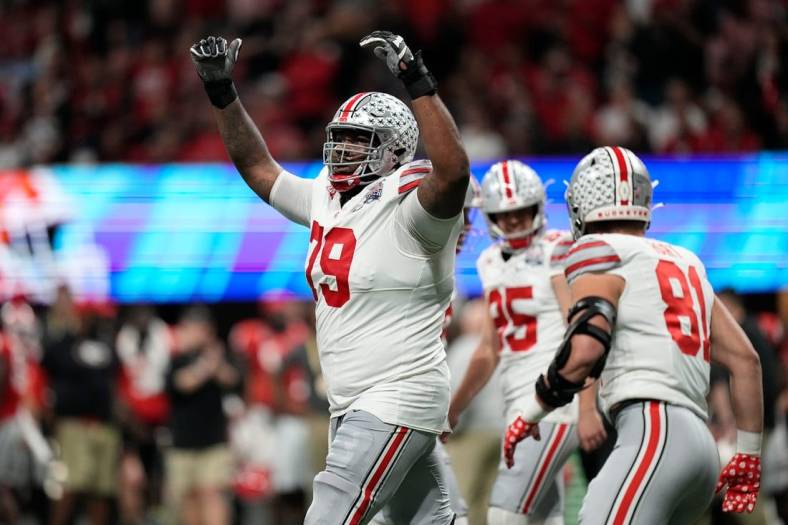 Dec 31, 2022; Atlanta, Georgia, USA; Ohio State Buckeyes offensive lineman Dawand Jones (79) celebrates a touchdown by wide receiver Marvin Harrison Jr. (18) during the first half of the Peach Bowl in the College Football Playoff semifinal at Mercedes-Benz Stadium. Mandatory Credit: Adam Cairns-The Columbus Dispatch

Ncaa Football Peach Bowl Ohio State At Georgia