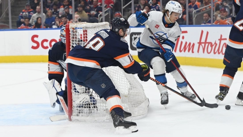 Dec 31, 2022; Edmonton, Alberta, CAN; Winnipeg Jets centre Morgan Barron (36) controls the puck as Edmonton Oilers left wing Zach Hyman (18) defends behind the net of goalie Jack Campbell (36) during the second period at Rogers Place. Mandatory Credit: Walter Tychnowicz-USA TODAY Sports