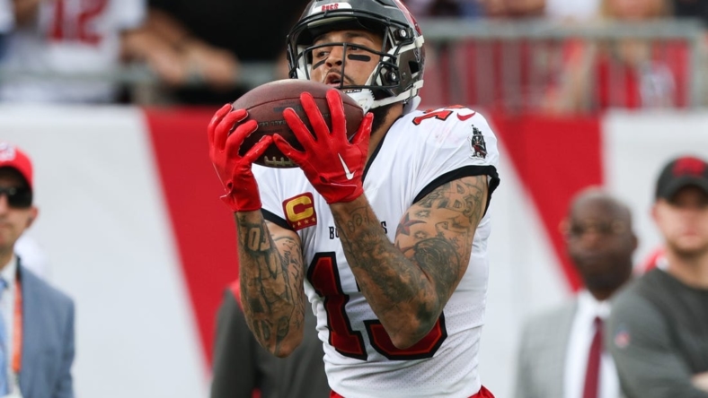 Jan 1, 2023; Tampa, Florida, USA;  Tampa Bay Buccaneers wide receiver Mike Evans (13) catches a pass from touchdown against the Carolina Panthers in the second quarter at Raymond James Stadium. Mandatory Credit: Nathan Ray Seebeck-USA TODAY Sports
