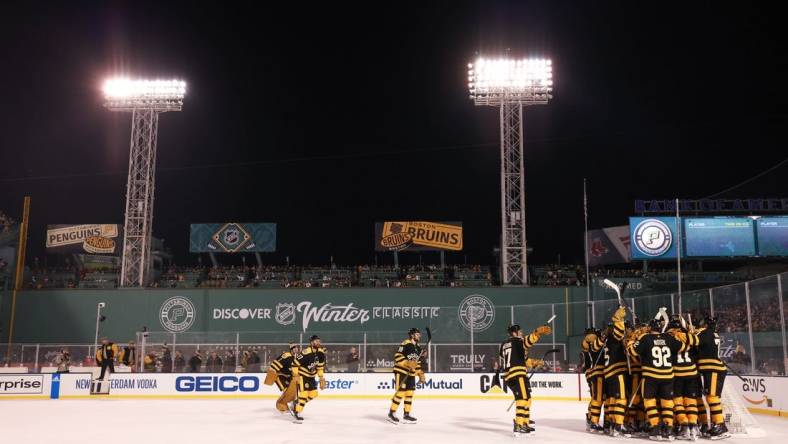 Jan 2, 2023; Boston, Massachusetts, USA; The Boston Bruins celebrate after defeating the Pittsburgh Penguins during the 2023 Winter Classic ice hockey game at Fenway Park. Mandatory Credit: Paul Rutherford-USA TODAY Sports