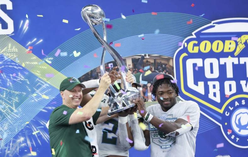 Jan 2, 2023; Arlington, Texas, USA; Tulane Green Wave head coach Willie Fritz lifts the Cotton Bowl trophy with Tulane Green Wave linebacker Dorian Williams (2) and Tulane Green Wave running back Tyjae Spears (22) after the game against the USC Trojans in the 2023 Cotton Bowl at AT&T Stadium. Mandatory Credit: Kevin Jairaj-USA TODAY Sports