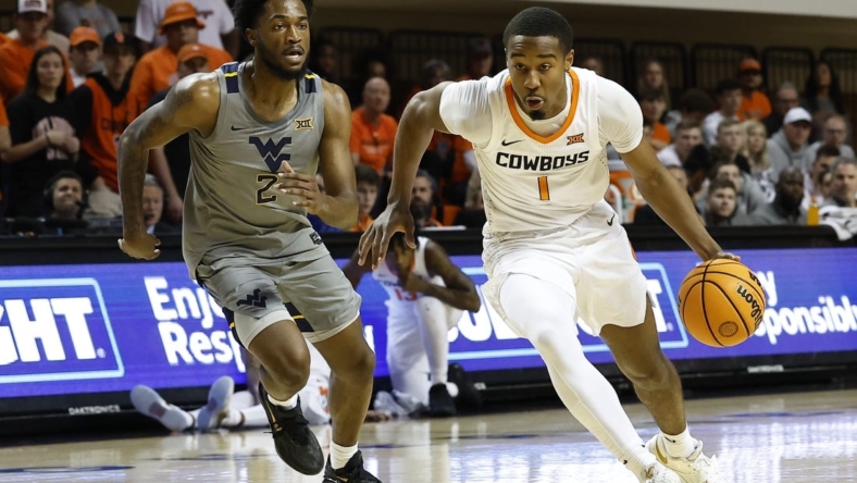 Jan 2, 2023; Stillwater, Oklahoma, USA; Oklahoma State Cowboys guard Bryce Thompson (1) drives to the basket ahead of West Virginia Mountaineers guard Kobe Johnson (2) during the first half at Gallagher-Iba Arena. Mandatory Credit: Alonzo Adams-USA TODAY Sports