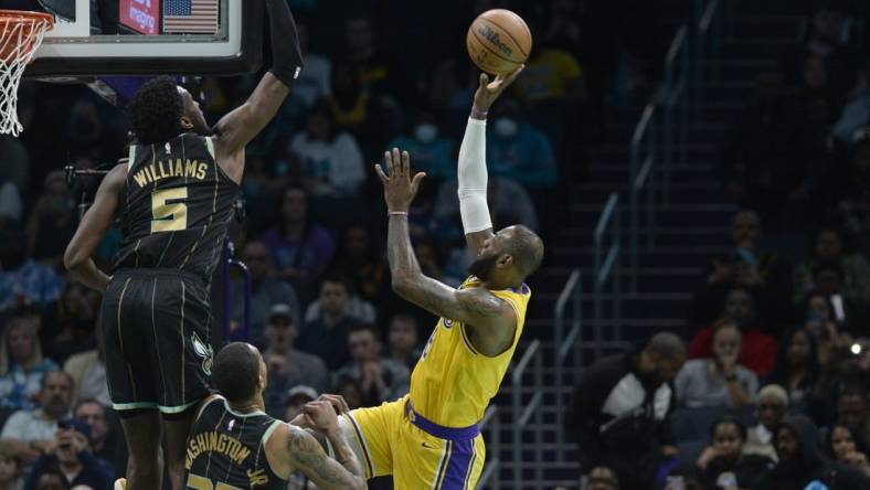 Jan 2, 2023; Charlotte, North Carolina, USA; Los Angeles Lakers forward LeBron James (6) shoots as he is defended by Charlotte Hornets center Mark Williams (5) and forward P.J. Washington (25) during first half at the Spectrum Center. Mandatory Credit: Sam Sharpe-USA TODAY Sports