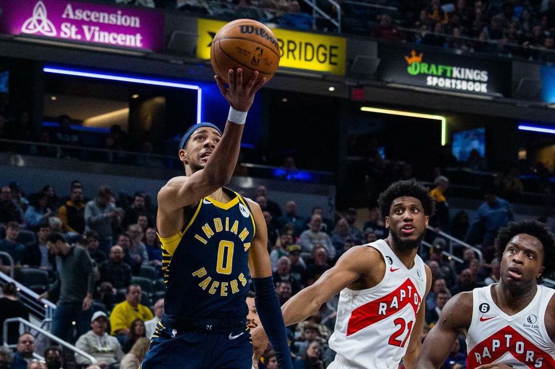 Jan 2, 2023; Indianapolis, Indiana, USA; Indiana Pacers guard Tyrese Haliburton (0) shoots the ball while Toronto Raptors forward Thaddeus Young (21)  defends in the second quarter at Gainbridge Fieldhouse. Mandatory Credit: Trevor Ruszkowski-USA TODAY Sports