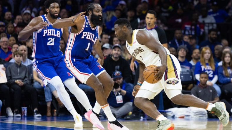 Jan 2, 2023; Philadelphia, Pennsylvania, USA; New Orleans Pelicans forward Zion Williamson (1) drives against Philadelphia 76ers guard James Harden (1) and center Joel Embiid (21) during the second quarter at Wells Fargo Center. Mandatory Credit: Bill Streicher-USA TODAY Sports