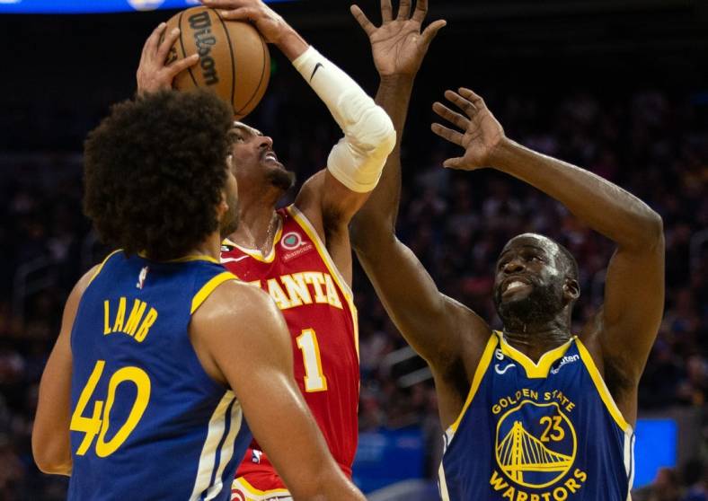 Jan 2, 2023; San Francisco, California, USA; Atlanta Hawks guard Trae Young (11) drives to the basket between Golden State Warriors forwards Anthony Lamb (40) and Draymond Green (23)  during the second quarter at Chase Center. Mandatory Credit: D. Ross Cameron-USA TODAY Sports