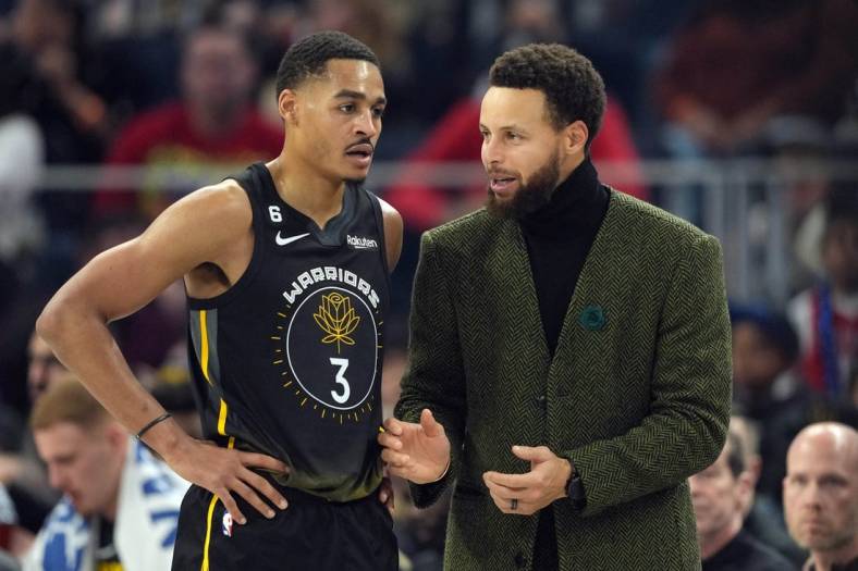 Dec 25, 2022; San Francisco, California, USA; Golden State Warriors guard Stephen Curry (right) talks to guard Jordan Poole (3) during the first quarter against the Memphis Grizzlies at Chase Center. Mandatory Credit: Darren Yamashita-USA TODAY Sports