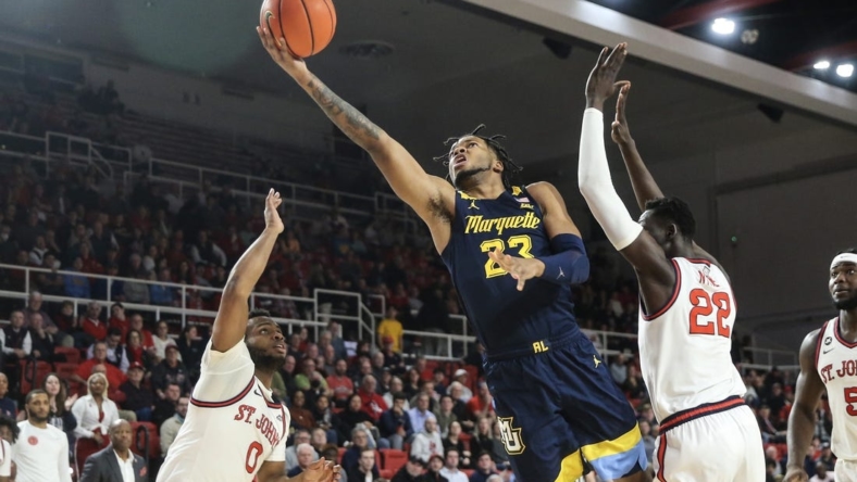 Jan 3, 2023; Queens, New York, USA; Marquette Golden Eagles forward David Joplin (23) drives past St. John's Red Storm forward Esahia Nyiwe (22) for a layup in the first half at Carnesecca Arena. Mandatory Credit: Wendell Cruz-USA TODAY Sports