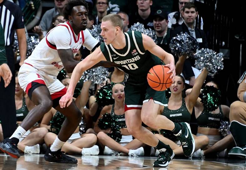 Jan 3, 2023; East Lansing, Michigan, USA;  Michigan State Spartans forward Joey Hauser (10) drives past Nebraska Cornhuskers forward Juwan Gary (4) in the first half at Jack Breslin Student Events Center. Mandatory Credit: Dale Young-USA TODAY Sports