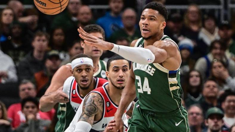 Jan 3, 2023; Milwaukee, Wisconsin, USA; Milwaukee Bucks forward Giannis Antetokounmpo (34) passes the ball away from Washington Wizards forward Kyle Kuzma (33) in the first quarter at Fiserv Forum. Mandatory Credit: Benny Sieu-USA TODAY Sports