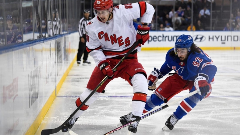 Jan 3, 2023; New York, New York, USA; Carolina Hurricanes center Martin Necas (88) and New York Rangers center Mika Zibanejad (93) battle along the boards during the second period at Madison Square Garden. Mandatory Credit: Dennis Schneidler-USA TODAY Sports