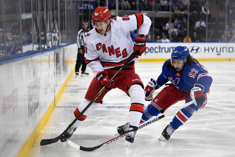 Jan 3, 2023; New York, New York, USA; Carolina Hurricanes center Martin Necas (88) and New York Rangers center Mika Zibanejad (93) battle along the boards during the second period at Madison Square Garden. Mandatory Credit: Dennis Schneidler-USA TODAY Sports