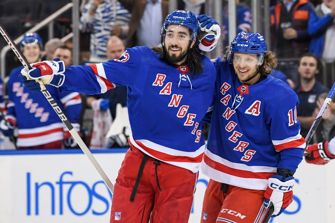 Jan 3, 2023; New York, New York, USA; New York Rangers left wing Artemi Panarin (10) celebrates the goal by New York Rangers center Mika Zibanejad (93) against the Carolina Hurricanes during the second period at Madison Square Garden. Mandatory Credit: Dennis Schneidler-USA TODAY Sports