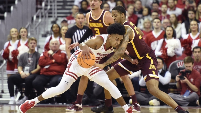 Jan 3, 2023; Madison, Wisconsin, USA; Wisconsin Badgers guard Chucky Hepburn (23) dribbles the ball under coverage by Minnesota Golden Gophers guard Ta'lon Cooper (55) during the first half at the Kohl Center. Mandatory Credit: Kayla Wolf-USA TODAY Sports