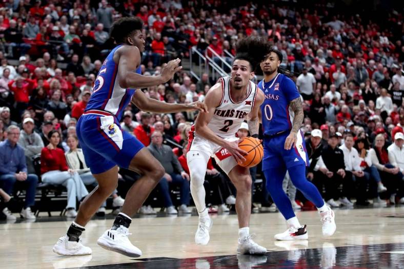 Jan 3, 2023; Lubbock, Texas, USA;  Texas Tech Red Raiders guard Pop Isaacs (2) drives to the lane against Kansas Jayhawks forward Zuby Ejiofor (35) in the first half at United Supermarkets Arena. Mandatory Credit: Michael C. Johnson-USA TODAY Sports