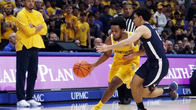 Jan 3, 2023; Pittsburgh, Pennsylvania, USA; Pittsburgh Panthers guard Nelly Cummings (0) drives to the basket against Virginia Cavaliers guard Kihei Clark (right) during the second half at the Petersen Events Center. Pittsburgh won 68-65. Mandatory Credit: Charles LeClaire-USA TODAY Sports