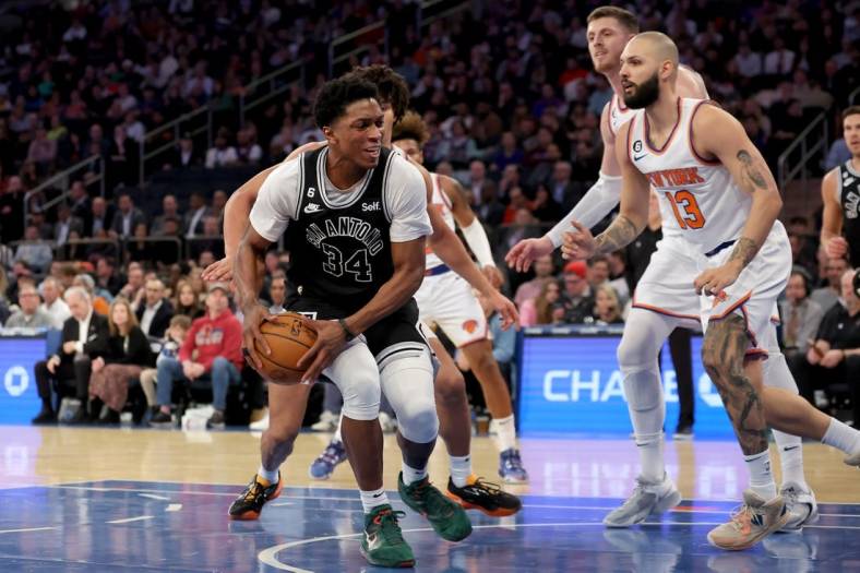 Jan 4, 2023; New York, New York, USA; San Antonio Spurs forward Stanley Johnson (34) drives to the basket against New York Knicks center Jericho Sims (45) and guard Evan Fournier (13) during the second quarter at Madison Square Garden. Mandatory Credit: Brad Penner-USA TODAY Sports