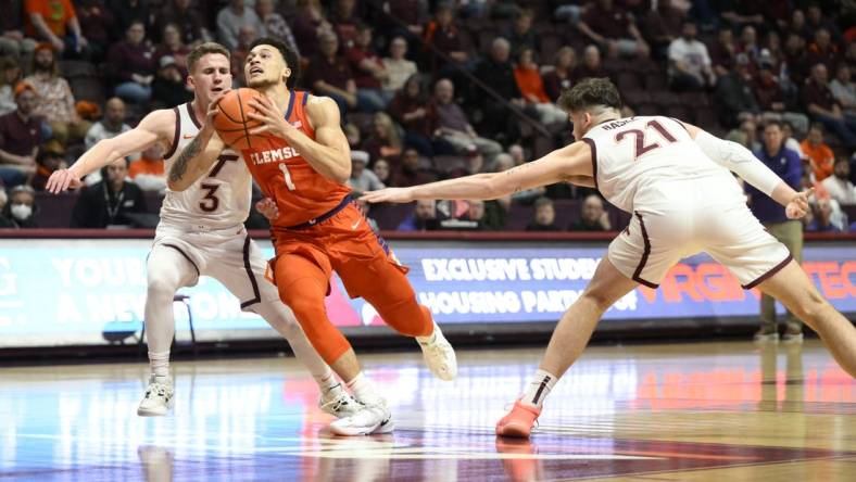 Jan 4, 2023; Blacksburg, Virginia, USA; Clemson Tigers guard Chase Hunter (1) drives to basket between Virginia Tech Hokies guard Sean Pedulla (3) and forward Grant Basile (21)  in the first halfat Cassell Coliseum. Mandatory Credit: Lee Luther Jr.-USA TODAY Sports