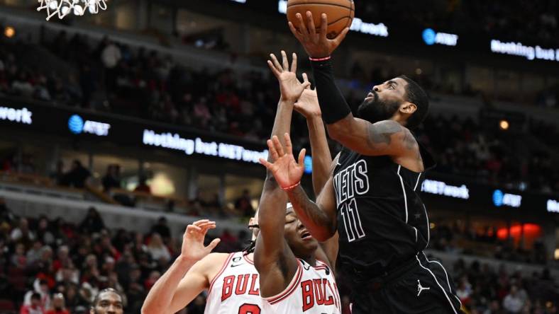 Jan 4, 2023; Chicago, Illinois, USA; Brooklyn Nets guard Kyrie Irving (11) shoots in the second half against Chicago Bulls guard Ayo Dosunmu (12) at United Center. Mandatory Credit: Quinn Harris-USA TODAY Sports