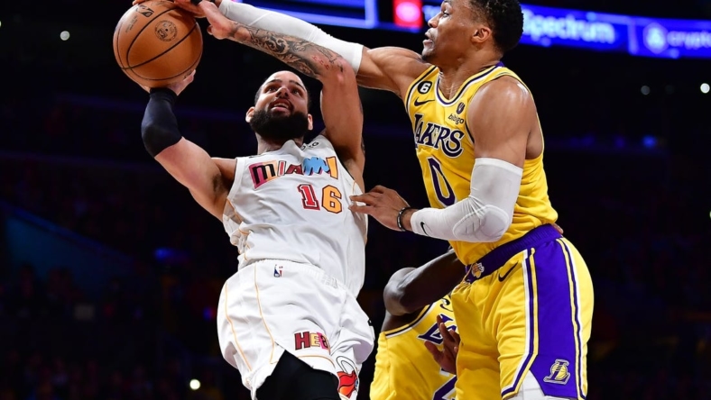 Jan 4, 2023; Los Angeles, California, USA; Miami Heat forward Caleb Martin (16) shoots against Los Angeles Lakers guard Russell Westbrook (0) during the first half at Crypto.com Arena. Mandatory Credit: Gary A. Vasquez-USA TODAY Sports