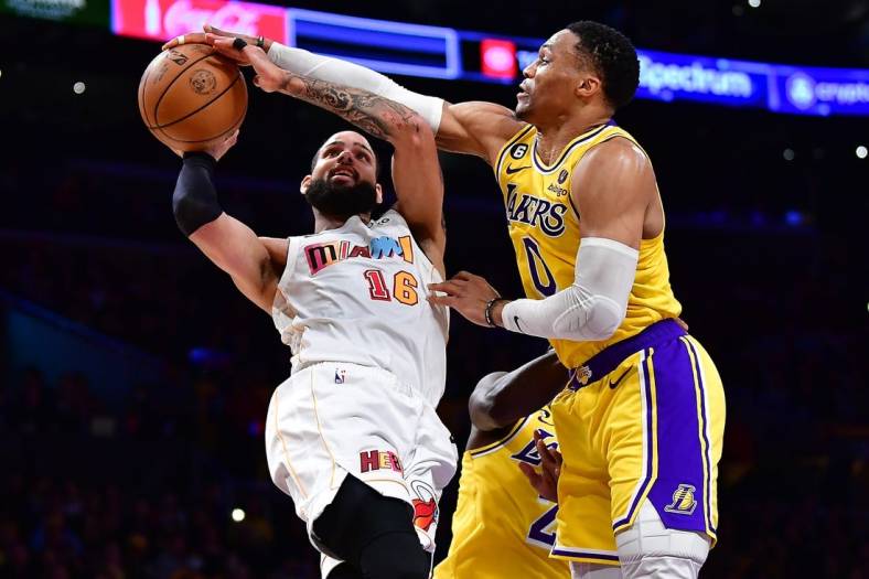 Jan 4, 2023; Los Angeles, California, USA; Miami Heat forward Caleb Martin (16) shoots against Los Angeles Lakers guard Russell Westbrook (0) during the first half at Crypto.com Arena. Mandatory Credit: Gary A. Vasquez-USA TODAY Sports