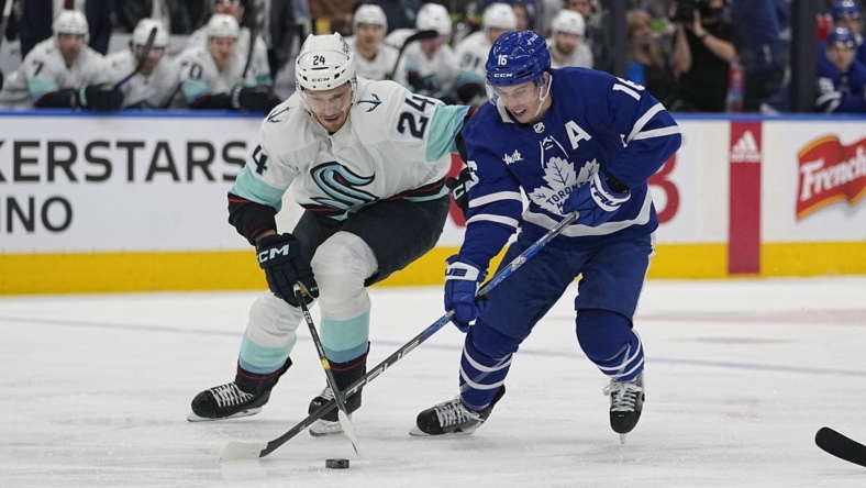Jan 5, 2023; Toronto, Ontario, CAN; Toronto Maple Leafs forward Mitchell Marner (16) and Seattle Kracken defenseman Jamie Oleksiak (24) battle for the puck during the first period at Scotiabank Arena. Mandatory Credit: John E. Sokolowski-USA TODAY Sports