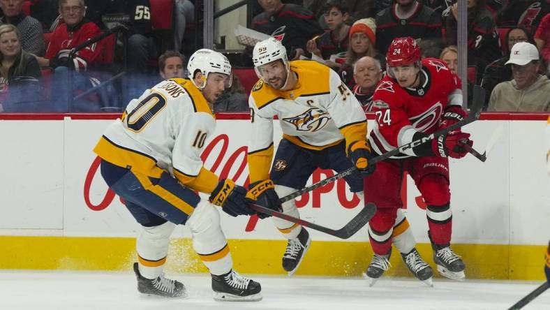 Jan 5, 2023; Raleigh, North Carolina, USA;  Nashville Predators center Colton Sissons (10) and defenseman Roman Josi (59) watch the puck against Carolina Hurricanes center Seth Jarvis (24) during the first period at PNC Arena. Mandatory Credit: James Guillory-USA TODAY Sports