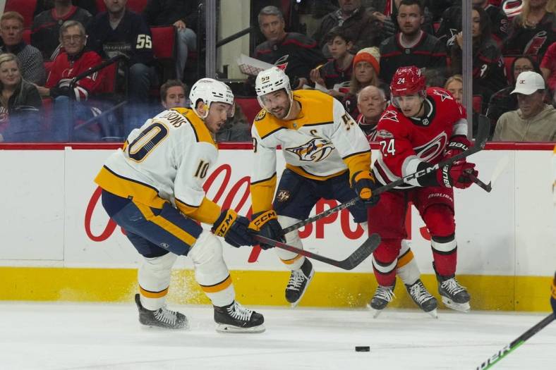 Jan 5, 2023; Raleigh, North Carolina, USA;  Nashville Predators center Colton Sissons (10) and defenseman Roman Josi (59) watch the puck against Carolina Hurricanes center Seth Jarvis (24) during the first period at PNC Arena. Mandatory Credit: James Guillory-USA TODAY Sports