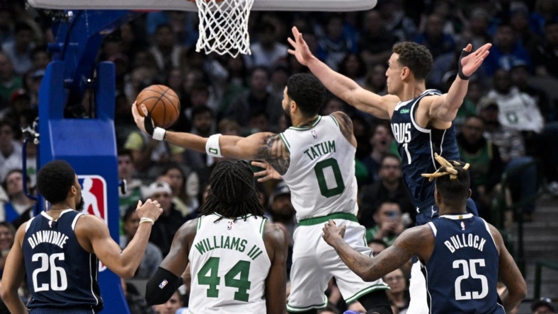 Jan 5, 2023; Dallas, Texas, USA; Boston Celtics forward Jayson Tatum (0) drives to the basket past Dallas Mavericks guard Spencer Dinwiddie (26) and forward Reggie Bullock (25) and center Dwight Powell (7) during the second half at the American Airlines Center. Mandatory Credit: Jerome Miron-USA TODAY Sports