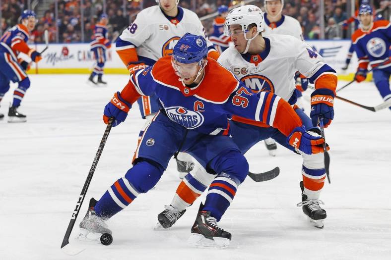 Jan 5, 2023; Edmonton, Alberta, CAN; Edmonton Oilers forward Connor McDavid (97) protects the puck from New York Islanders forward Jean-Gabriel Pageau (44) during the third period at Rogers Place. Mandatory Credit: Perry Nelson-USA TODAY Sports