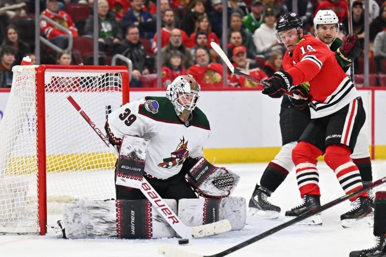 Jan 6, 2023; Chicago, Illinois, USA;  Arizona Coyotes goaltender Connor Ingram (39) makes a save as Chicago Blackhawks forward Jonathan Toews (19) looks for the rebound in the first period at United Center. Mandatory Credit: Jamie Sabau-USA TODAY Sports