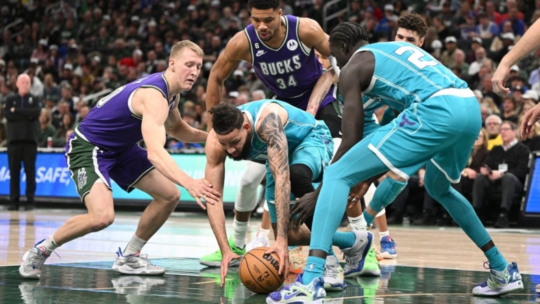 Jan 6, 2023; Milwaukee, Wisconsin, USA; Charlotte Hornets forward Cody Martin (11) and Milwaukee Bucks guard AJ Green (20) scramble for a loose ball in the first half at Fiserv Forum. Mandatory Credit: Michael McLoone-USA TODAY Sports