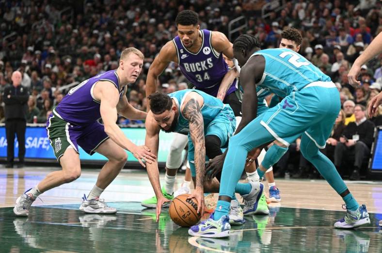 Jan 6, 2023; Milwaukee, Wisconsin, USA; Charlotte Hornets forward Cody Martin (11) and Milwaukee Bucks guard AJ Green (20) scramble for a loose ball in the first half at Fiserv Forum. Mandatory Credit: Michael McLoone-USA TODAY Sports