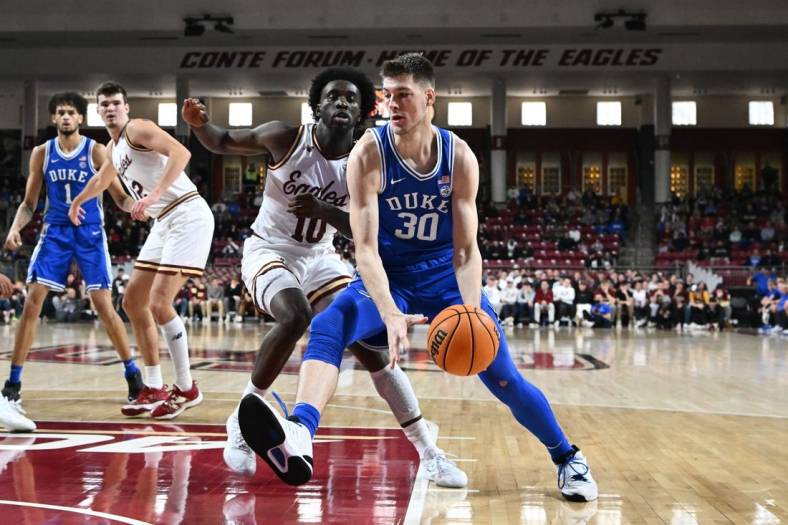 Jan 7, 2023; Chestnut Hill, Massachusetts, USA; Duke Blue Devils center Kyle Filipowski (30) drives to the basket against Boston College Eagles guard Prince Aligbe (10) during the first half at the Conte Forum. Mandatory Credit: Brian Fluharty-USA TODAY Sports