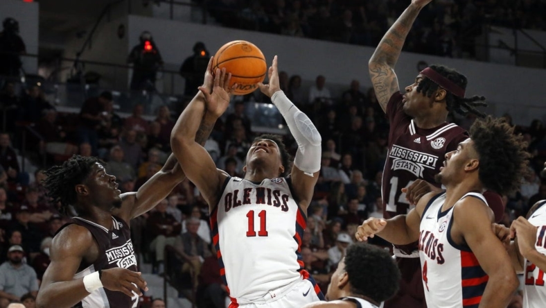 Jan 7, 2023; Starkville, Mississippi, USA; Mississippi Rebels guard Matthew Murrell (11) shoots as Mississippi State Bulldogs guard/forward Cameron Matthews (4) fouls him during the first half at Humphrey Coliseum. Mandatory Credit: Petre Thomas-USA TODAY Sports