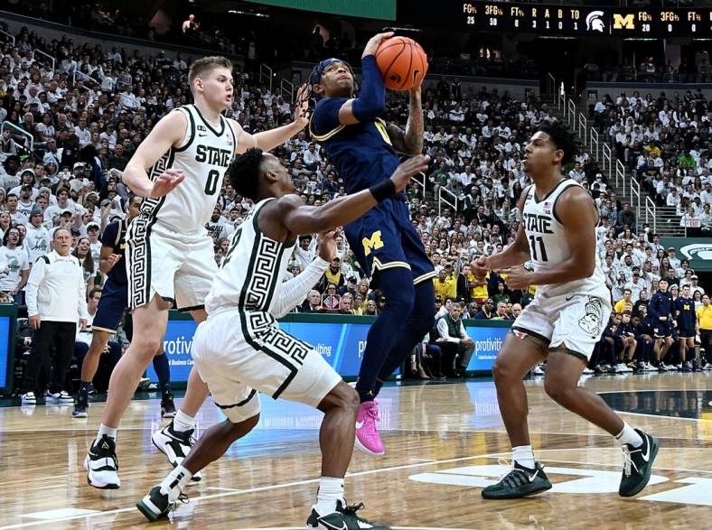 Jan 7, 2023; East Lansing, Michigan, USA;  Michigan Wolverines guard Dug McDaniel (0) drives to the net against the Michigan State Spartans defense in the first half  at Jack Breslin Student Events Center. Mandatory Credit: Dale Young-USA TODAY Sports