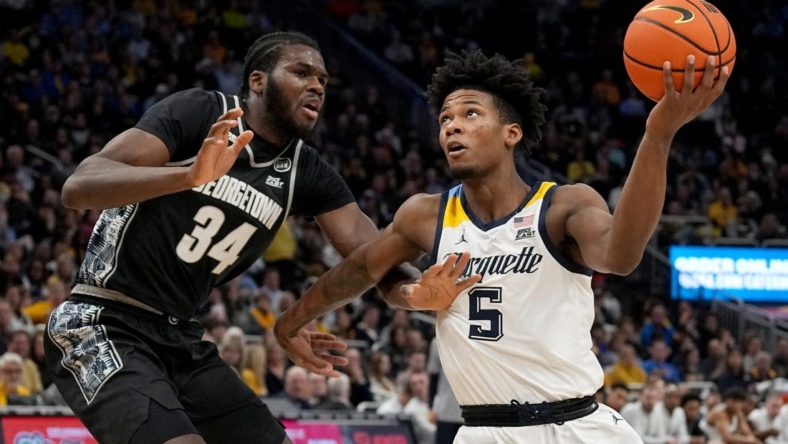 Jan 7, 2023; Milwaukee, Wisconsin, USA; Marquette Golden Eagles guard Chase Ross (5) drives past Georgetown Hoyas center Qudus Wahab (34) during the first half of their game at Fiserv Forum. Mandatory Credit: Mark Hoffman-USA TODAY Sports