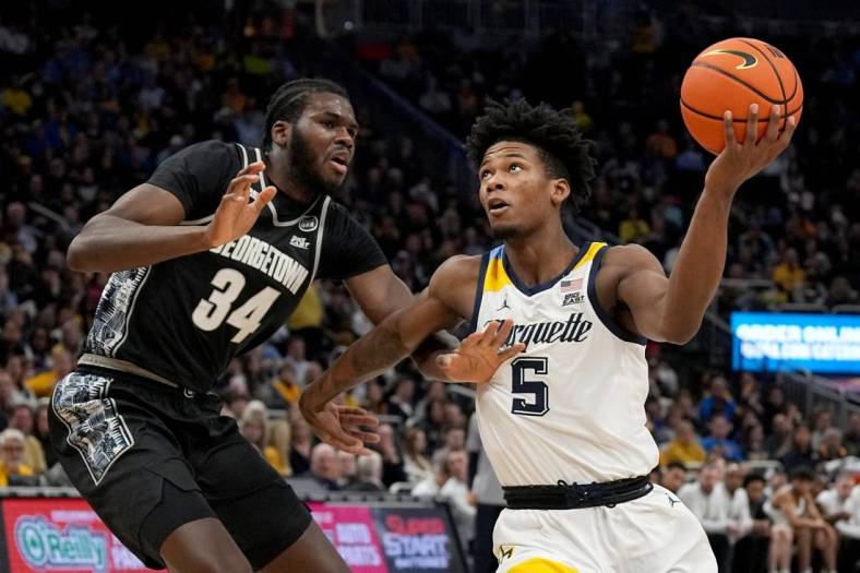 Jan 7, 2023; Milwaukee, Wisconsin, USA; Marquette Golden Eagles guard Chase Ross (5) drives past Georgetown Hoyas center Qudus Wahab (34) during the first half of their game at Fiserv Forum. Mandatory Credit: Mark Hoffman-USA TODAY Sports