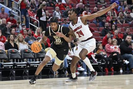 Jan 7, 2023; Louisville, Kentucky, USA;  Wake Forest Demon Deacons guard Damari Monsanto (30) dribbles against Louisville Cardinals forward Jae'Lyn Withers (24) during the first half at KFC Yum! Center. Mandatory Credit: Jamie Rhodes-USA TODAY Sports