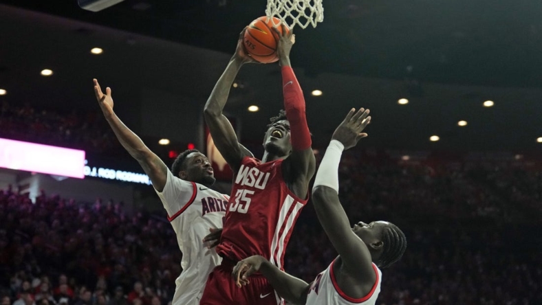 Jan 7, 2023; Tucson, Arizona, USA; Washington State Cougars forward Mouhamed Gueye (35) goes up for a layup against Arizona Wildcats guard Courtney Ramey (0) and Arizona Wildcats center Oumar Ballo (11) during the first half at McKale Center. Mandatory Credit: Joe Camporeale-USA TODAY Sports