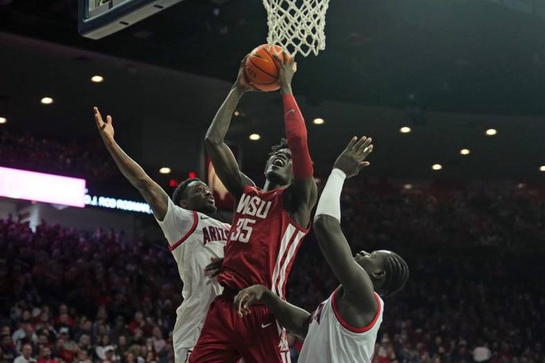 Jan 7, 2023; Tucson, Arizona, USA; Washington State Cougars forward Mouhamed Gueye (35) goes up for a layup against Arizona Wildcats guard Courtney Ramey (0) and Arizona Wildcats center Oumar Ballo (11) during the first half at McKale Center. Mandatory Credit: Joe Camporeale-USA TODAY Sports