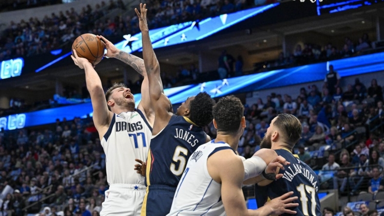 Jan 7, 2023; Dallas, Texas, USA; Dallas Mavericks guard Luka Doncic (77) shoots over New Orleans Pelicans forward Herbert Jones (5) and center Jonas Valanciunas (17) during the first quarter at the American Airlines Center. Mandatory Credit: Jerome Miron-USA TODAY Sports
