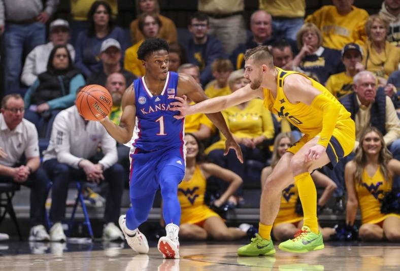 Jan 7, 2023; Morgantown, West Virginia, USA; Kansas Jayhawks guard Joseph Yesufu (1) passes the ball while being defended by West Virginia Mountaineers guard Erik Stevenson (10) during the second half at WVU Coliseum. Mandatory Credit: Ben Queen-USA TODAY Sports
