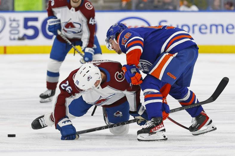 Jan 7, 2023; Edmonton, Alberta, CAN; Edmonton Oilers forward Kailer Yamamoto (56) battles for a loose puck against Colorado Avalanche defensemen Jacob O Connor (26) during the second period at Rogers Place. Mandatory Credit: Perry Nelson-USA TODAY Sports