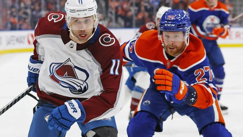 Jan 7, 2023; Edmonton, Alberta, CAN; Colorado Avalanche forward Andrew Cogliano (11) and Edmonton Oilers defensemen Brett Kulak (27) chase a loose puck during the second period at Rogers Place. Mandatory Credit: Perry Nelson-USA TODAY Sports