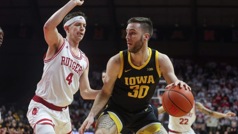 Jan 8, 2023; Piscataway, New Jersey, USA; Iowa Hawkeyes guard Connor McCaffery (30) dribbles against Rutgers Scarlet Knights guard Paul Mulcahy (4) during the first half at Jersey Mike's Arena. Mandatory Credit: Vincent Carchietta-USA TODAY Sports