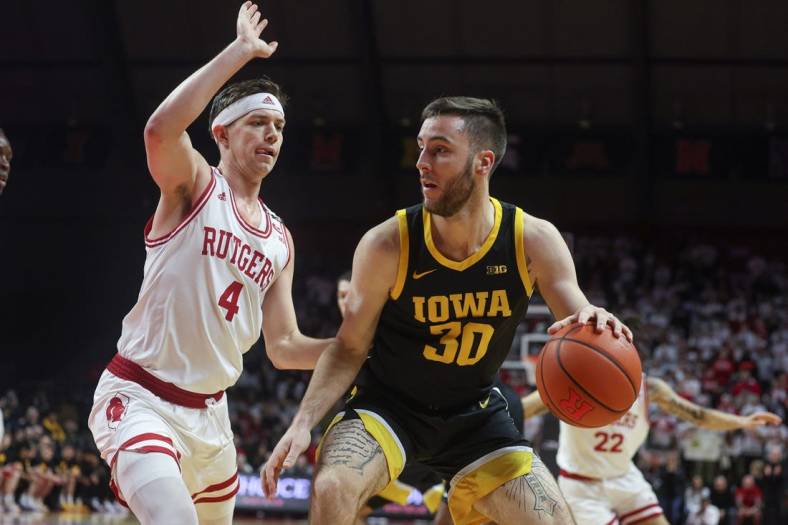 Jan 8, 2023; Piscataway, New Jersey, USA; Iowa Hawkeyes guard Connor McCaffery (30) dribbles against Rutgers Scarlet Knights guard Paul Mulcahy (4) during the first half at Jersey Mike's Arena. Mandatory Credit: Vincent Carchietta-USA TODAY Sports