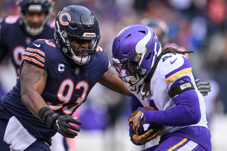 Jan 8, 2023; Chicago, Illinois, USA; Minnesota Vikings running back Dalvin Cook (4) runs the ball and is tackled by Chicago Bears defensive tackle Justin Jones (93) during the first quarter at Soldier Field. Mandatory Credit: Daniel Bartel-USA TODAY Sports
